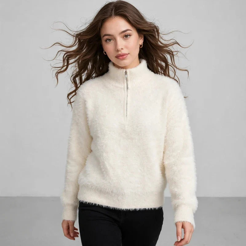Model in a cream fuzzy half-zip sweater with black pants, front view, against a light gray studio background.