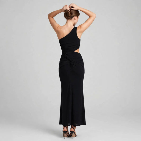 Back view of a black one-shoulder bodycon maxi dress with side waist cutout and ruched detailing, white studio background.