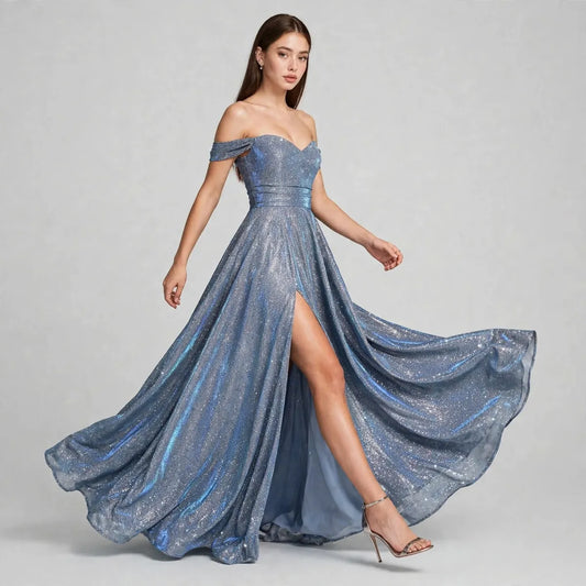 Woman wearing an off-the-shoulder blue sequin gown with high thigh slit and flowing skirt, gray studio background.