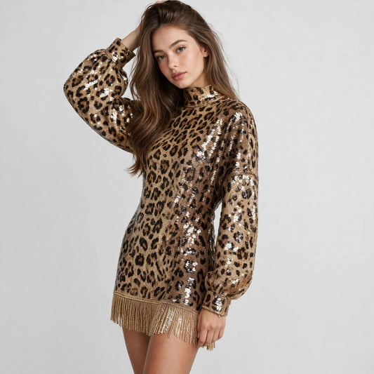 Front view of a leopard print sequin mini dress with mock neck, balloon sleeves and fringe hem, hand in hair, white backdrop.