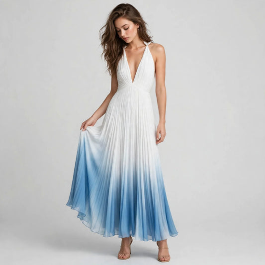 Front view of a barefoot woman in a sleeveless white-to-blue ombre pleated maxi dress with a deep V-neckline.