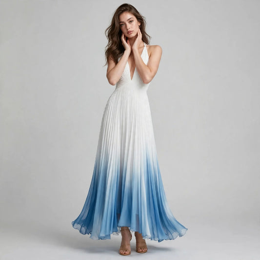 Front view of a woman with hands at neck wearing a white-to-blue ombre pleated maxi dress with a deep V-neck.