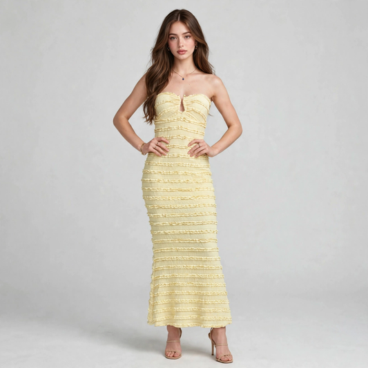 Woman modeling a strapless pale yellow textured maxi dress with ruched bodice, sweetheart neckline and fitted silhouette.