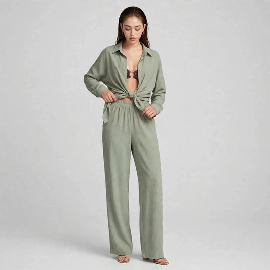 Woman modeling a sage green two-piece set with long-sleeve button-up shirt tied at the waist and matching wide-leg pants.