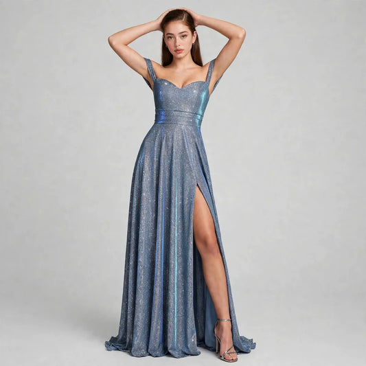 Woman in a shimmering blue-gray gown with sweetheart neckline, thin straps and high thigh slit, gray studio background.