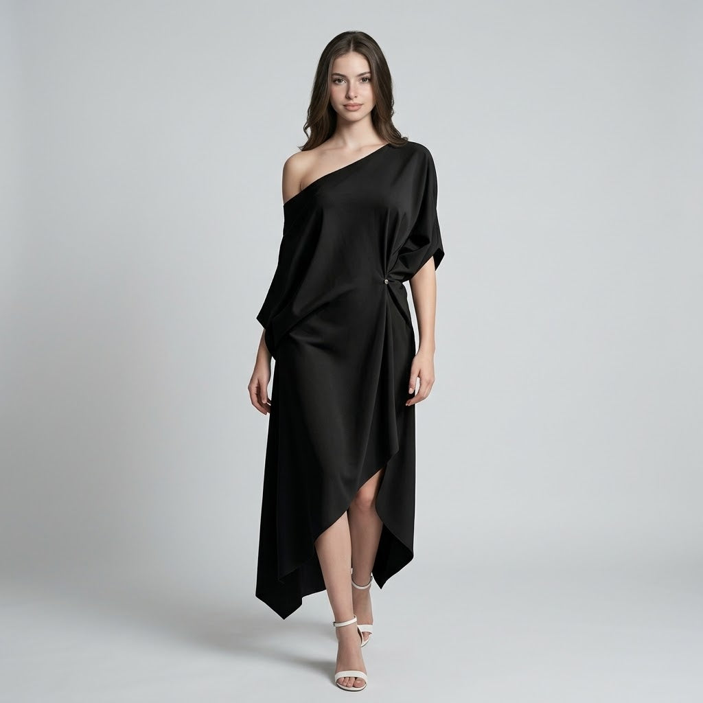 Woman modeling a black one-shoulder midi dress with draped asymmetrical wrap skirt, short sleeve and white strappy heels.