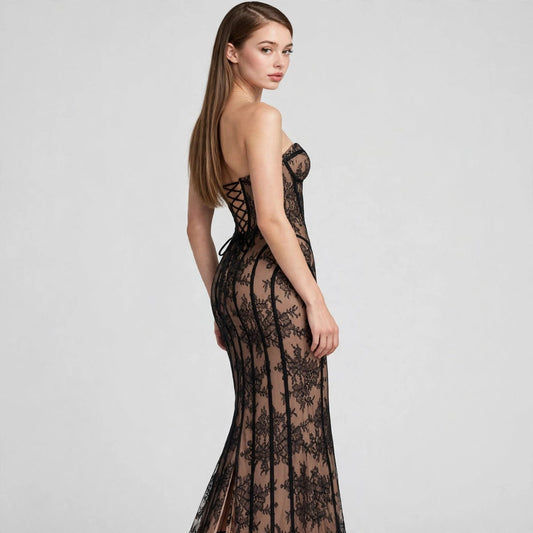 Three-quarter back view of black lace strapless maxi dress with corset bodice and sheer overlay, model, studio shot.
