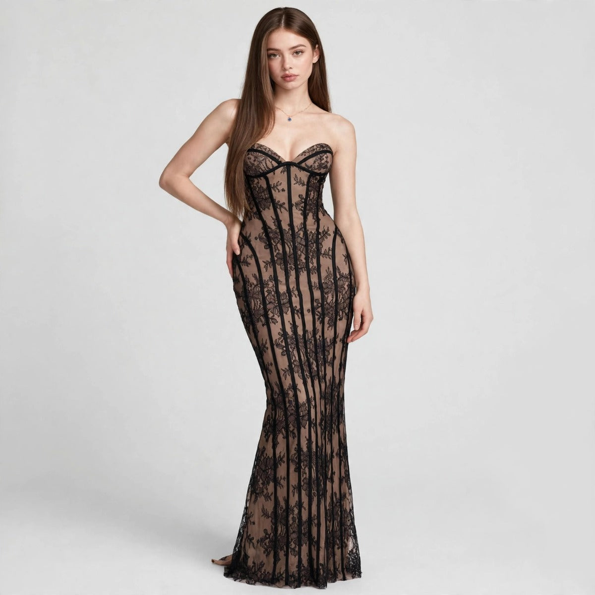 Model in black lace strapless maxi dress with corset boned bodice and sheer lace overlay, front view, studio backdrop.