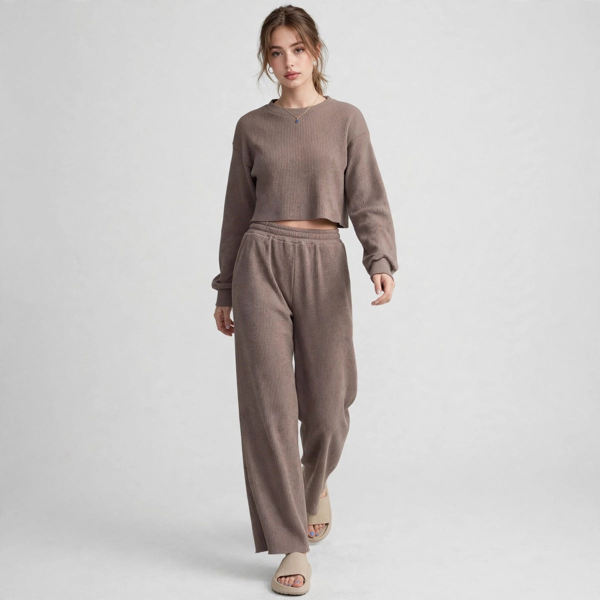 Model walking in brown waffle-knit cropped top and wide-leg pants loungewear set, full-length front view, studio shot.