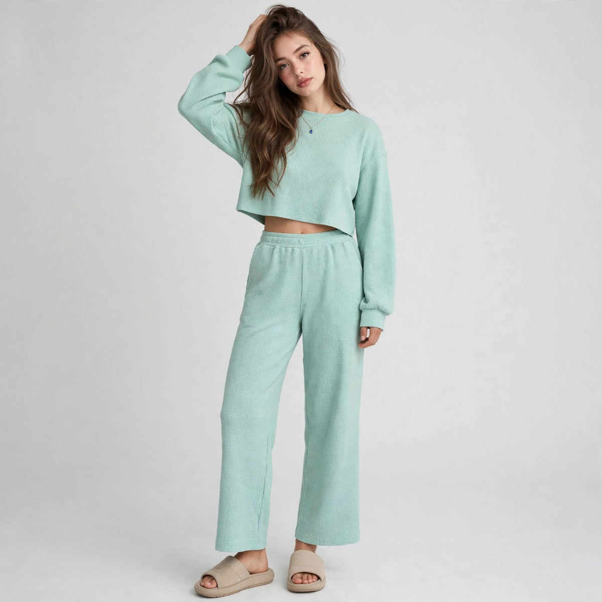 Model in mint waffle-knit cropped top and wide-leg pants loungewear set, hand on head, full-length studio portrait.