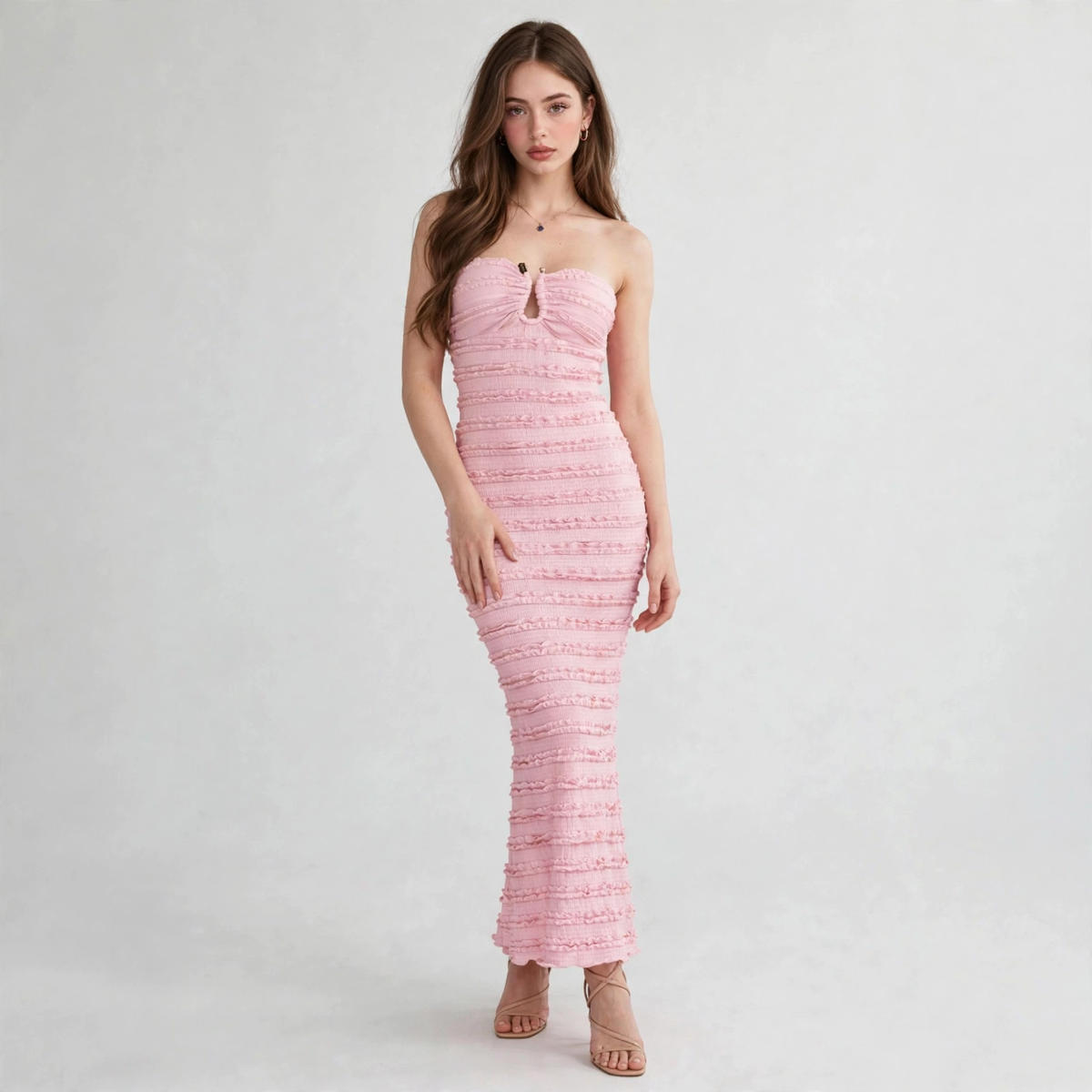 Woman modeling a strapless pink textured maxi dress with ruched bodice, sweetheart neckline and keyhole cutout at bust.
