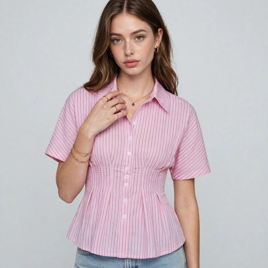 Close-up front view of a pink striped short-sleeve peplum button-up shirt with collar, model in jeans, gray studio.