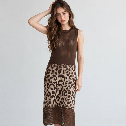 Front view of a brown sleeveless knit midi dress with leopard color-block skirt panel, model with hand in hair, studio.