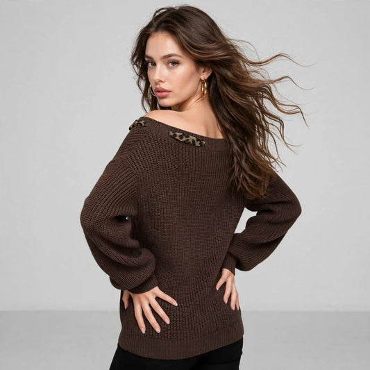 Back three-quarter view of a brown off-shoulder dropped-shoulder knit sweater, hands on hips, black pants, gray studio.